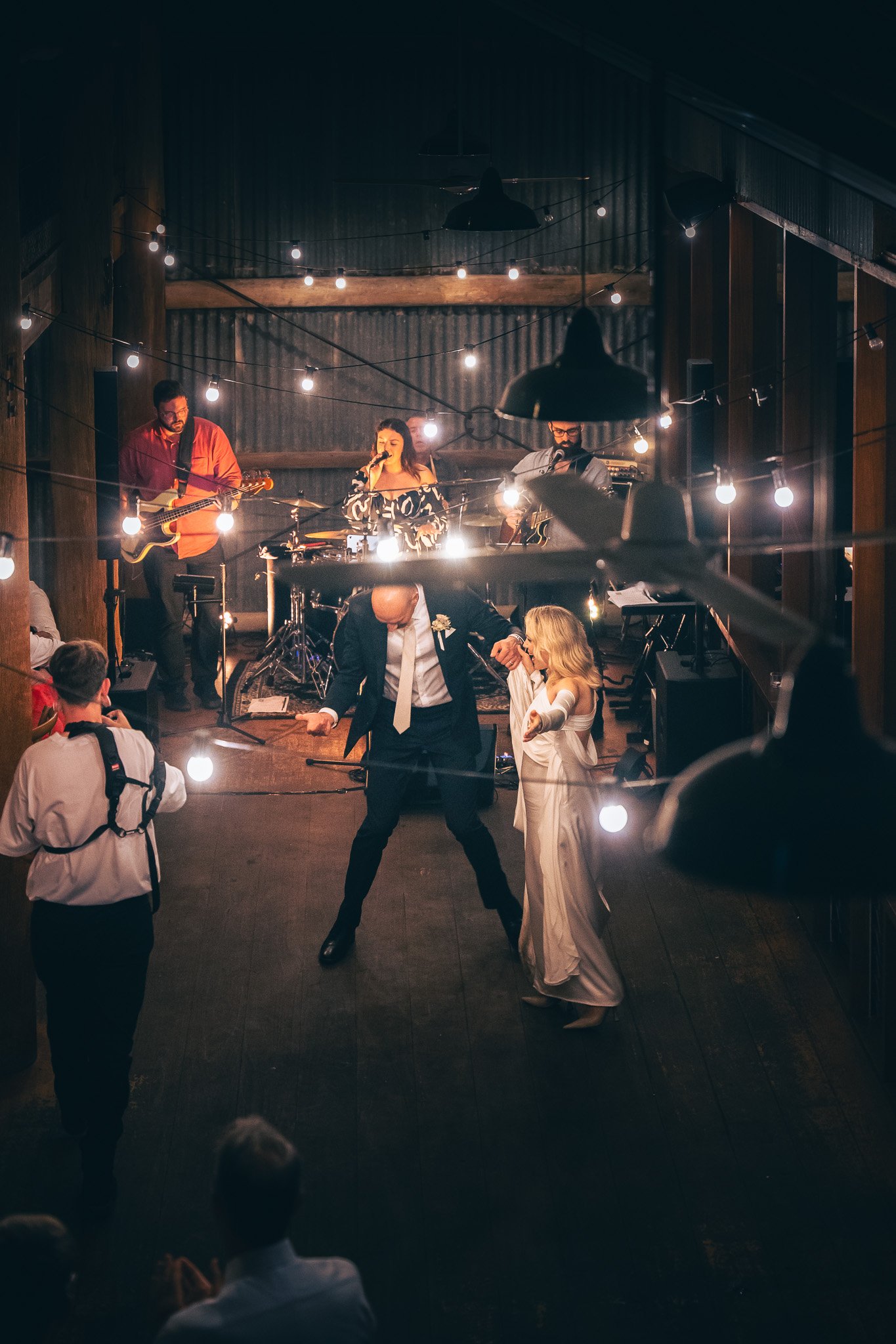 Aubrey performs on stage at a wedding reception in The Hunter Valley NSW, with the Bride and Groom dancing in front of the band, and guests watching and taking photos.