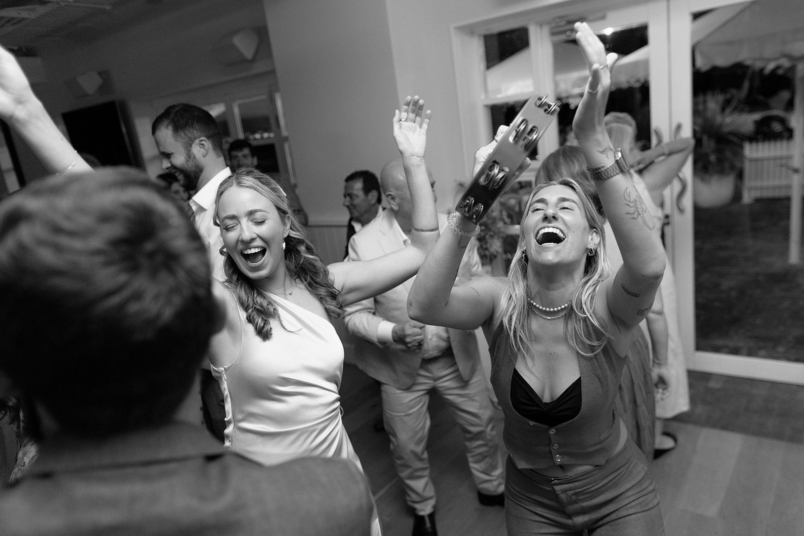 People dancing and celebrating at a wedding reception at Shoal Bay Country Club, smiling and having fun.